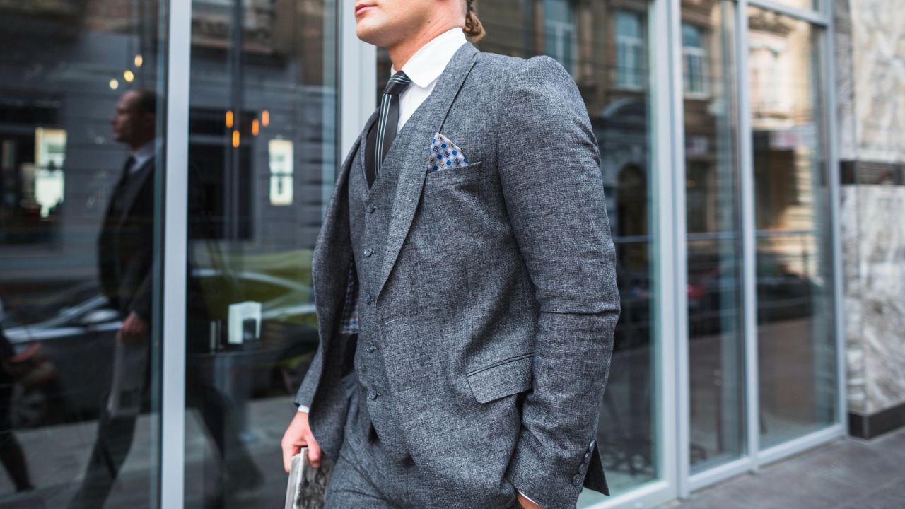 Dapper man walking confidently down a city street wearing a well-fitted suit jacket